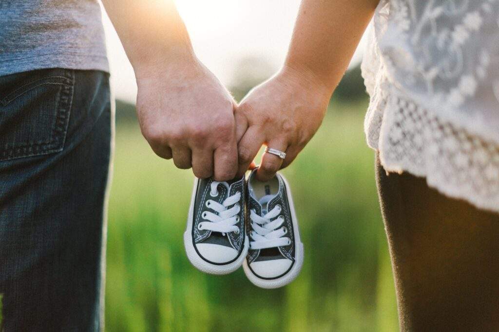 Parents Holding Baby Shoes